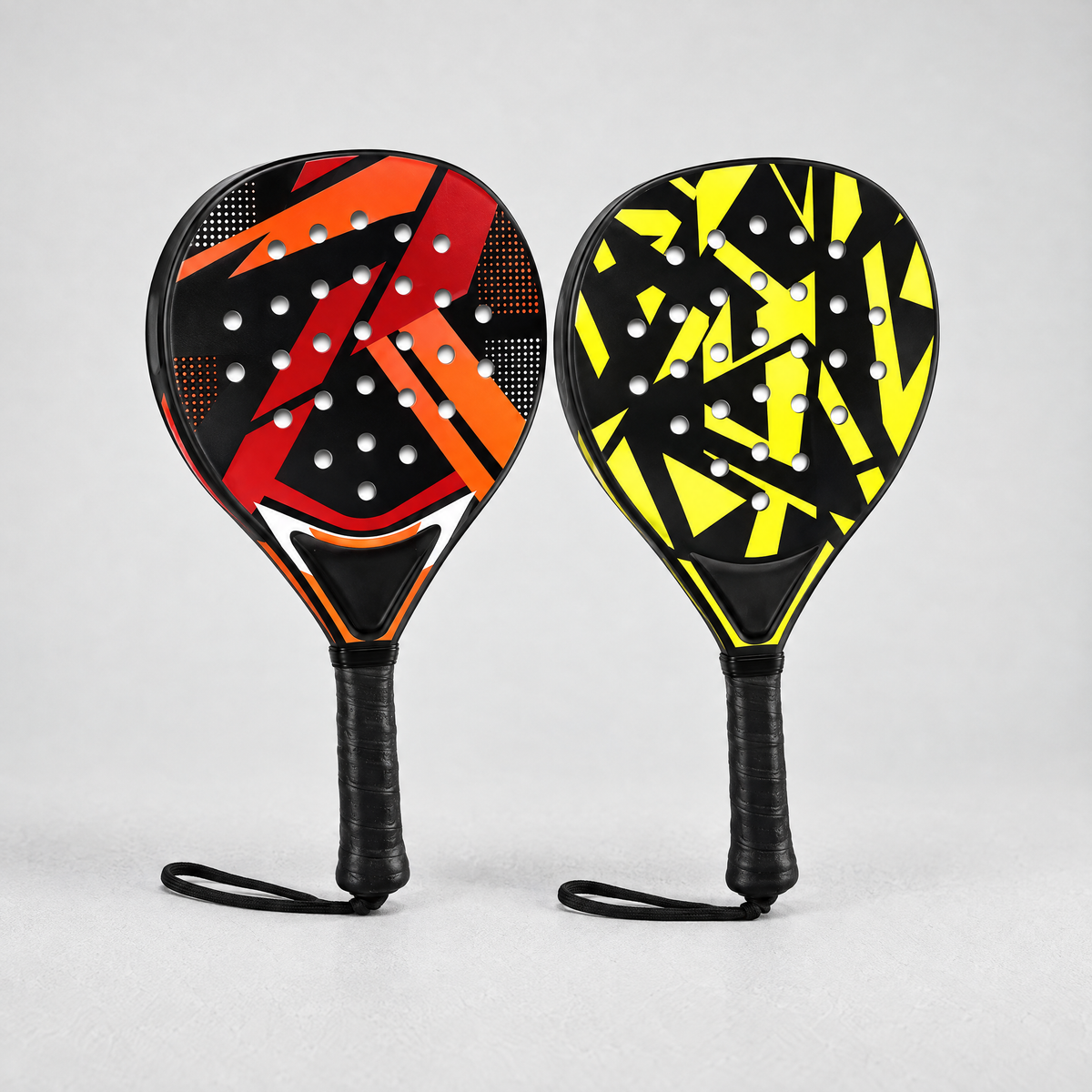 Two beginner padel rackets, red and yellow, side by side